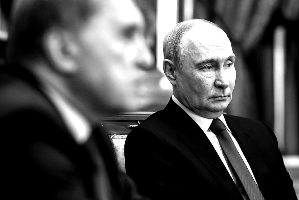 Vladimir Putin seated across from a U.S. envoy at the Kremlin.